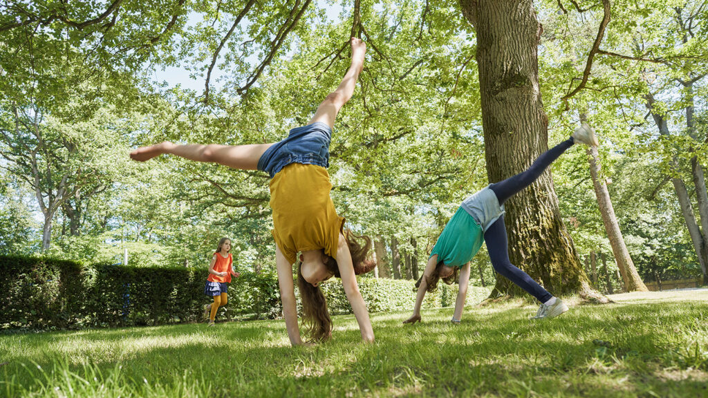 Children doing cartwheels on the grass