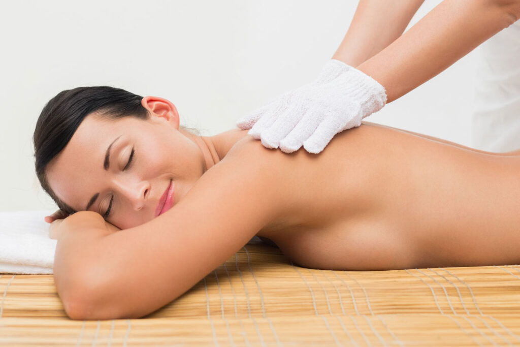 Frau bekommt Massage mit Handschuh