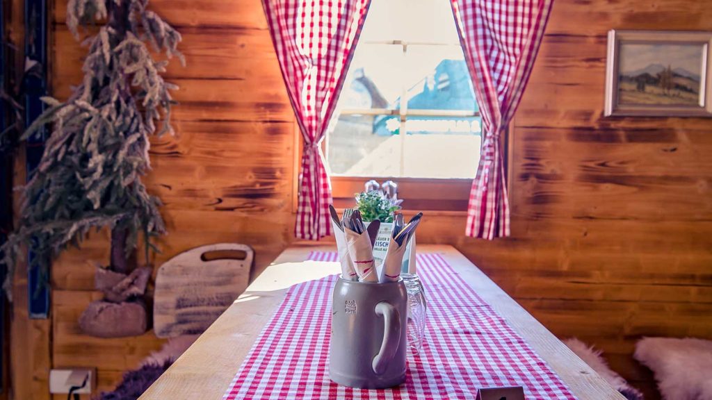 Tisch und Bank vor einem Fenster in der Martha die Hütte